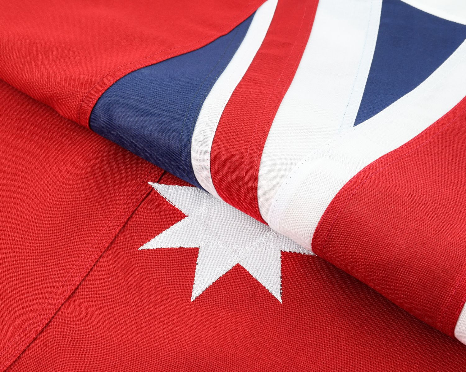 Folded historical 1901-1903 Australian Red Ensign showing red fabric and white star detail.