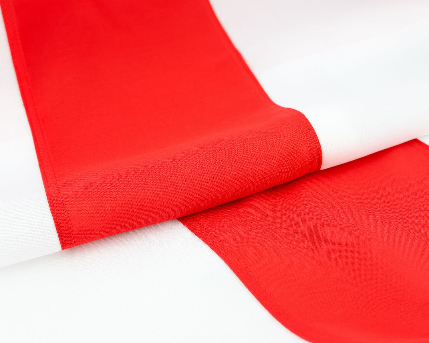 Close-up of the fully sewn England flag showing the red cross fabric and white field.