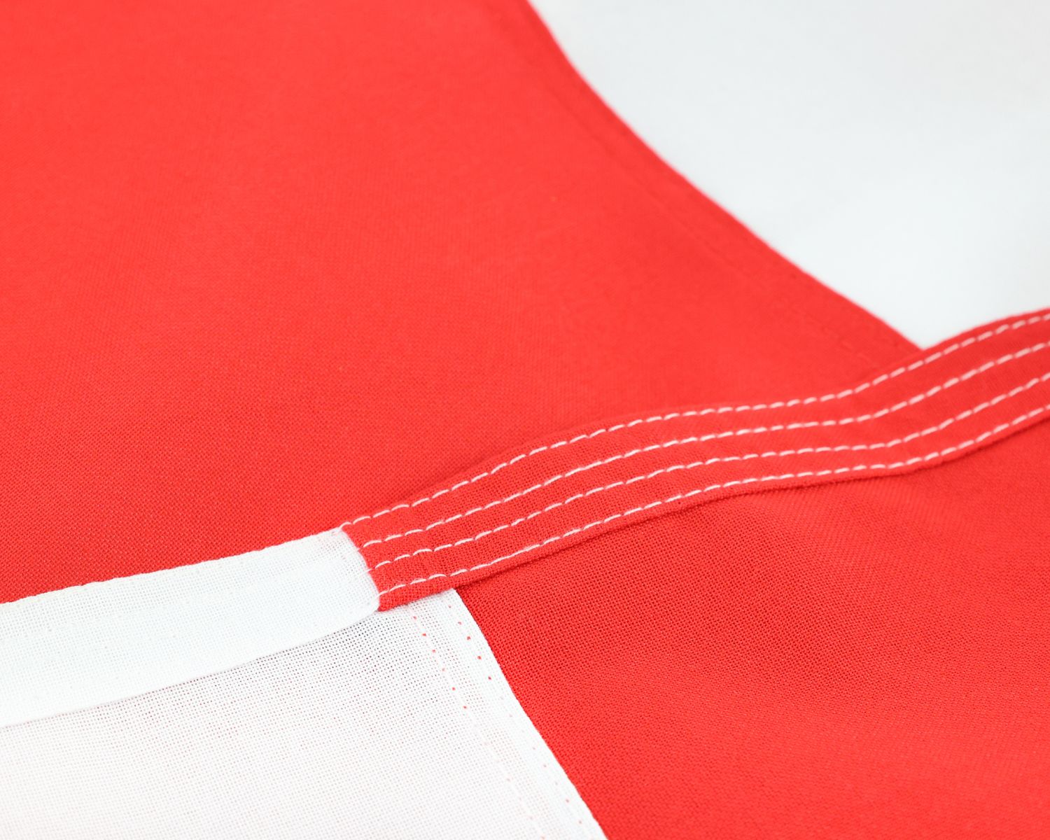 Close-up of the England flag edge showing reinforced stitching across the red and white fabric.