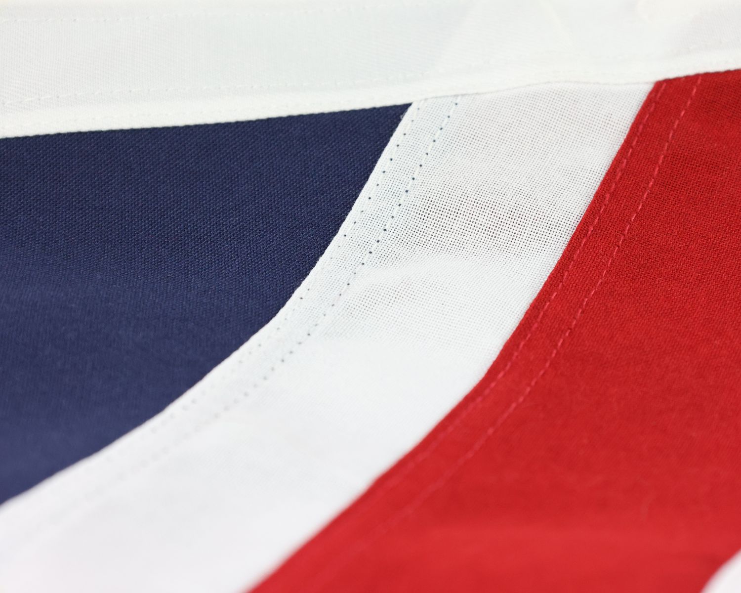 Close-up of the Union Flag showing sewn seams between the red, white and blue fabric sections.